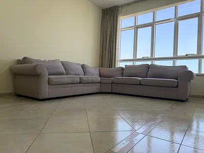 Light grey L-shaped 3-seater corner sofa with rolled arms
