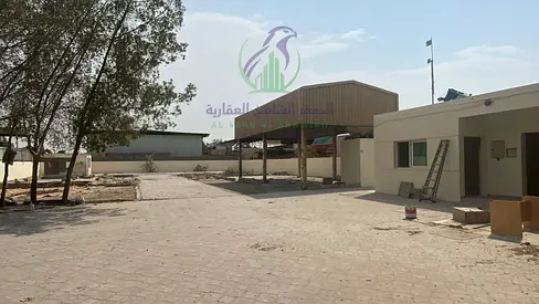 Industrial plot in Al Sajaa, located on the main road, featuring interlocking paving and an area of 20,000 square feet. It is equipped with 32 kW el