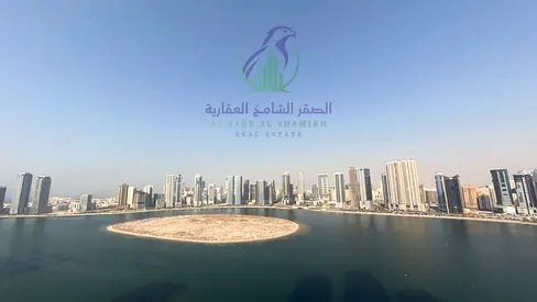 شقة غرفتين وصالة للإيجار في الشارقة بإطلالة بحرية، تشطيب ألترا لوكس، موقف سيارة، وتصميم عملي للسكن العائلي