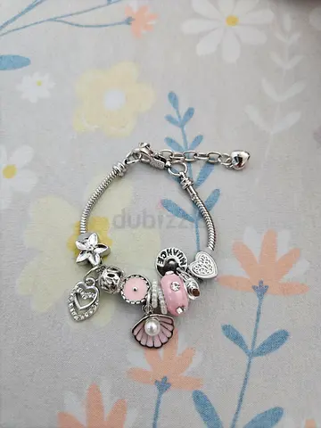 Silver charm bracelet with pink enamel and pearl shell charms