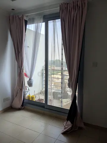 Pair of light pink blackout curtains with sheer liners along with the curtain rods.