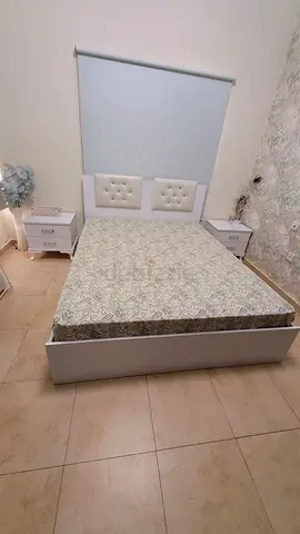 Queen bed frame with mattress and two bedside tables and dressing stand