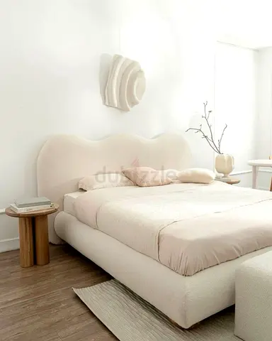 Cream upholstered double bed with curved headboard