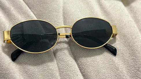 Gold oval frame sunglasses with black lenses