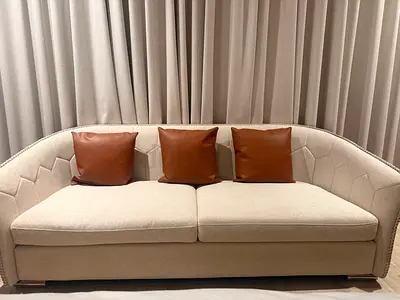 Light beige 3-seater sofa with curved back and leather cushions