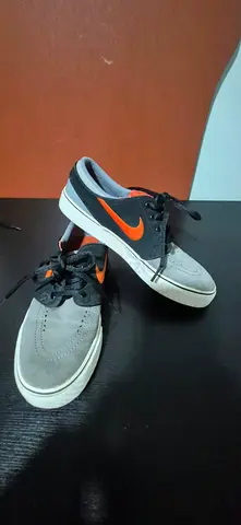 Used Nike low-top sneakers - grey & black with orange swoosh, size unknown