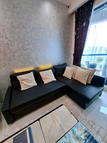 Large L-shaped black leatherite sofa — good condition, ideal for living room