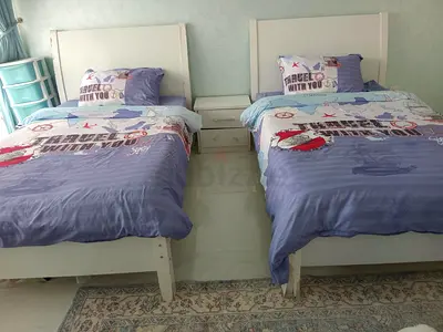 Pair of white single beds with bedside table - good condition