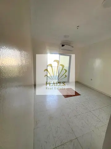 A one-bedroom apartment with a living room is available for annual rent in Al Nuaimiya 1, Ajman. It features an open view, a balcony, and split air co