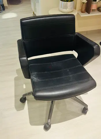 Black genuine leather swivel office chair with armrests and wheels
