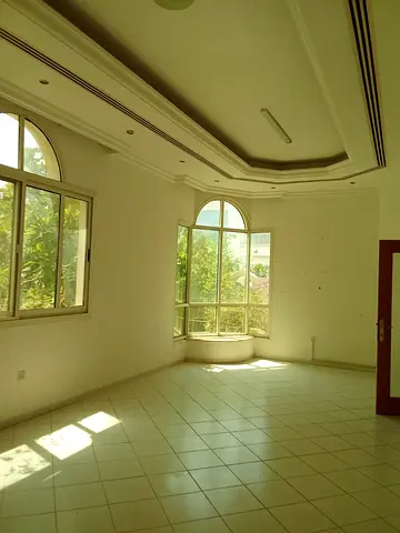 A four-bedroom villa with a majlis, living room, maid's room, spacious garden, and covered parking is available for annual rent in Sharjah. Spacious a