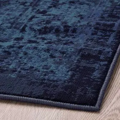 IKEA VONSBÄK low-pile rug in dark navy blue with a distressed vintage-style pattern.