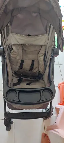 Lightly used beige baby stroller with tray and reclining seat