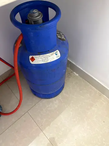 Used blue LPG gas cylinder with hose - working condition
