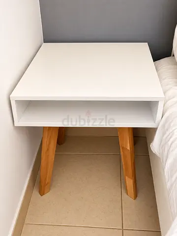 White bedside table with storage shelf and wooden legs