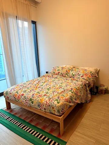Single wooden bed frame with mattress and floral bedding