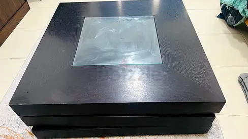 Black square wooden coffee table with glass inset along with