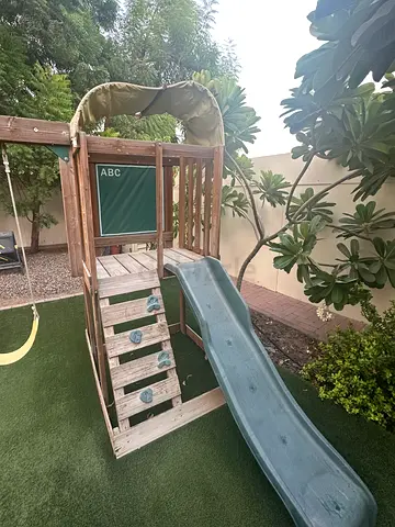 Wooden outdoor playset with slide and climbing ladder and swings - good condition