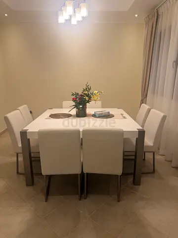 Modern white 8-seater dining table with upholstered chairs