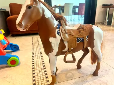 Brown and white toy horse with saddle and mane - good condition