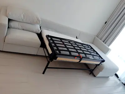 Light grey L-shaped sofa with pull-out bed - good condition