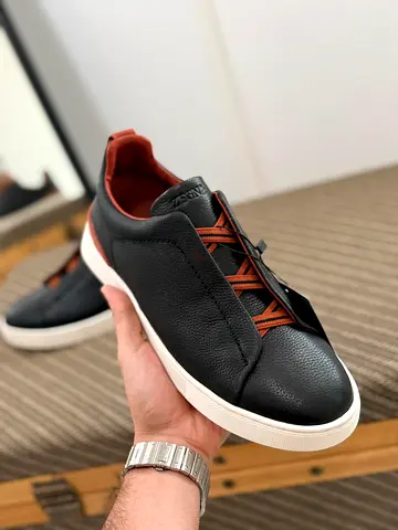 Black leather casual sneakers with brown accents — lightly used