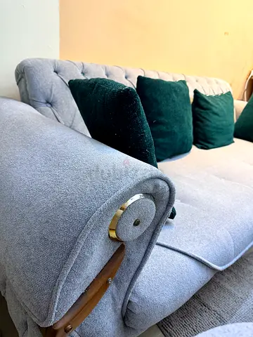 Light grey upholstered 3-seater sofa with green cushions’ Negotiable