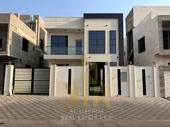 Modern villa for sale in Al Zahia, Ajman, featuring two floors plus a roof terrace and central air c