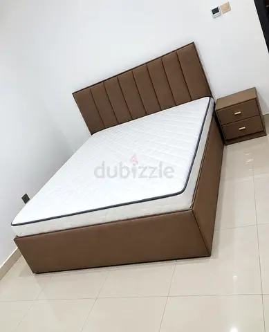 Brown upholstered double bed with mattress and matching bedside table