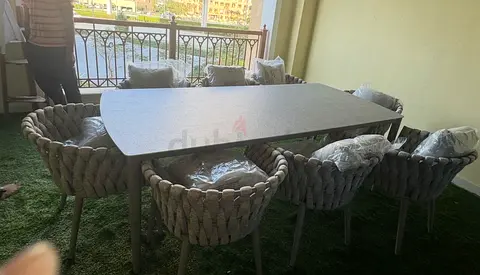 Outdoor dining table with 6 woven rope chairs - good condition