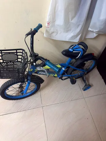 Kids blue bicycle with training wheels and front basket