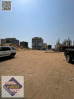 Residential-commercial land for sale in Ajman, with a permit for G+4 buildings and a prime location.