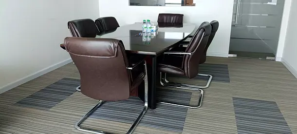 Used conference table with 6 brown leather visitor chairs — good condition