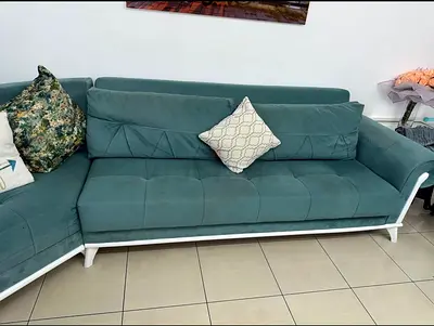 Light teal L-shaped fabric sofa with white wooden frame - good condition