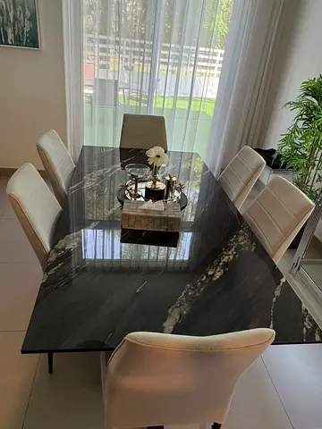 Modern black marble dining table with 6 cream upholstered chairs