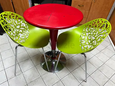 Small round bistro table with two decorative green chairs - used