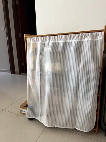 White bamboo shoe rack with a curtain