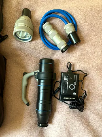 Diving equipment includes a large scuba diving light with a SCUBAPRO handle and its own battery char