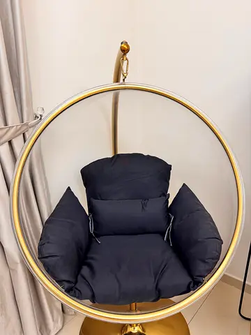 Gold hanging bubble chair with black cushions