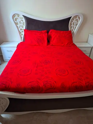 Queen-sized decorative bed frame with headboard and side tables