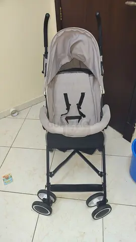 Lightweight umbrella stroller in good condition (Moov/brand visible) - beige