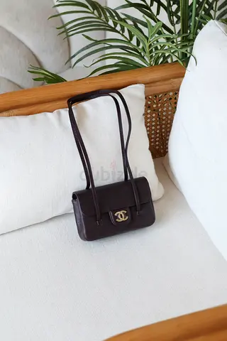 Small dark brown Chanel-style shoulder bag with gold CC clasp