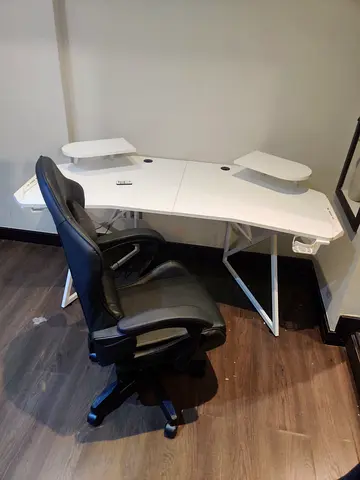 White corner study desk with adjustable shelves and black office chair