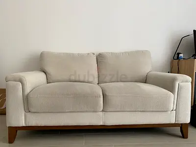 Beige 2-Seater Fabric Sofa with Wooden Base - Good Condition