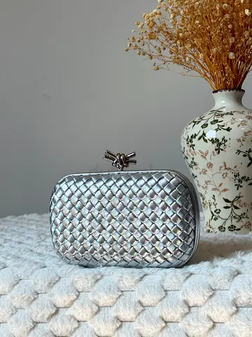 Silver woven clutch bag with knot clasp