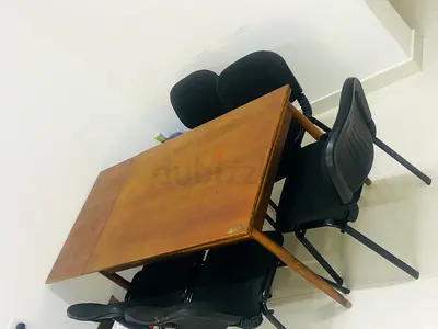 Wooden dining table with four black chairs -