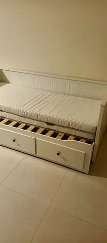White wooden daybed with storage drawers and mattress