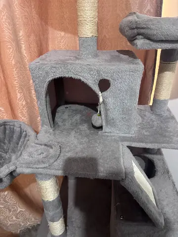 Grey multi-level cat tree with scratching posts and hideaway