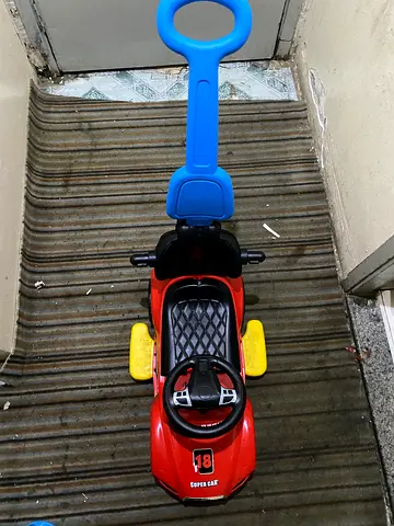 Red ride-on push car with steering and push handle - good condition