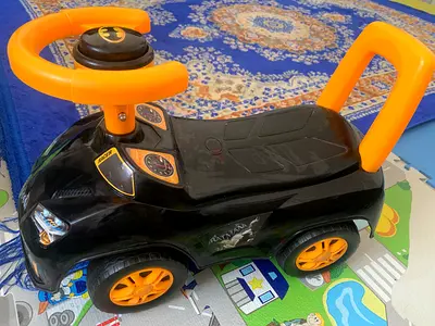 Baby ride-on car with Batman logo — black & orange, good condition